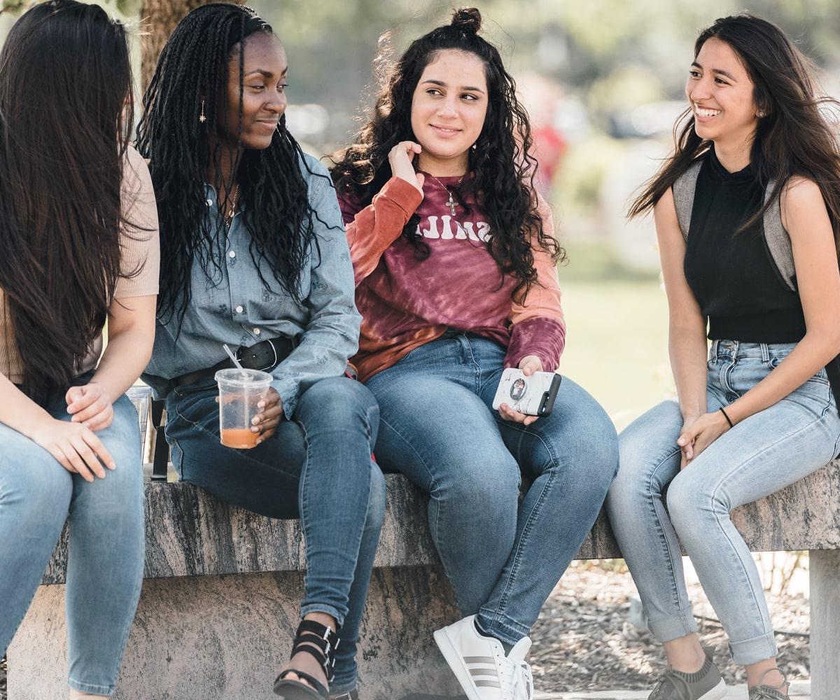 Four SXU students conversing on campus